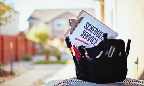 Air conditioner with maintenance tools and service reminder in residential back yard
